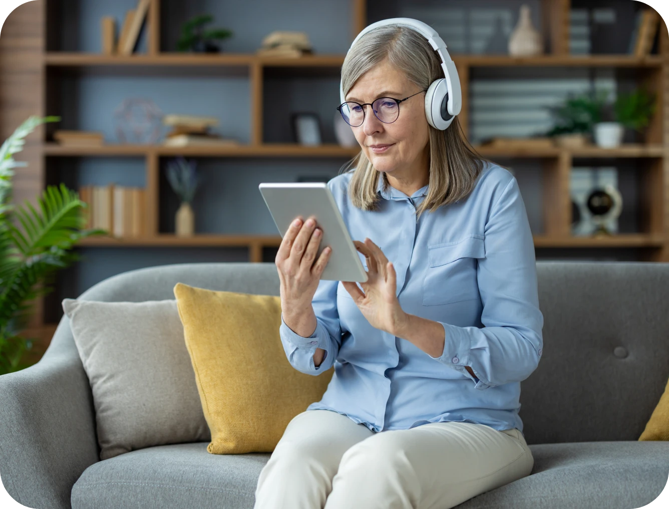 Older woman listening on tablet at home